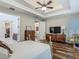 Bedroom featuring tray ceilings, wood flooring, and access to ensuite bathroom at 13525 Gorgona Isle Dr, Windermere, FL 34786
