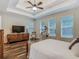 Bright bedroom featuring tray ceilings, wood flooring, and multiple large windows at 13525 Gorgona Isle Dr, Windermere, FL 34786