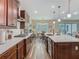 Bright kitchen showcasing stainless steel appliances, dark wood cabinetry, quartz countertops, and an adjacent dining area at 13525 Gorgona Isle Dr, Windermere, FL 34786