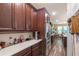 Bright kitchen highlighting quartz countertops, stainless steel appliances, and dark wood cabinetry with views into other spaces at 13525 Gorgona Isle Dr, Windermere, FL 34786