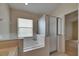 Bright bathroom featuring a soaking tub beneath a window and a separate glass-enclosed shower at 1003 Clearpointe Way, Lakeland, FL 33813