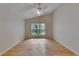 Bedroom featuring hardwood floors, ceiling fan, and a window providing natural light and a serene outdoor view at 1003 Clearpointe Way, Lakeland, FL 33813