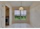 Bright dining area features tiled flooring, an elegant chandelier, and a window providing natural light and pleasant outdoor views at 1003 Clearpointe Way, Lakeland, FL 33813