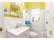 Well-lit bathroom featuring a vanity, mirror, and toilet with a window at 102 Pike St, Auburndale, FL 33823
