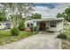 Charming single-story home with a covered carport, inviting front yard and beautiful landscaping at 102 Pike St, Auburndale, FL 33823