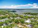 Serene aerial view showcasing homes nestled amidst lush greenery, near a tranquil lake under a blue sky at 110 N Tremain St # 206, Mount Dora, FL 32757