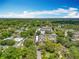 Wide aerial shot showcasing this property surrounded by lush greenery with multiple buildings and a pool under a sunny, blue sky at 110 N Tremain St # 206, Mount Dora, FL 32757