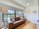 Bright living room with a leather sofa, large windows, and view to the outside at 110 N Tremain St # 206, Mount Dora, FL 32757