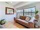 Bright living room with a leather sofa, large windows, and serene views of the pool area at 110 N Tremain St # 206, Mount Dora, FL 32757
