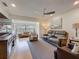 Bright living room featuring cozy seating, a ceiling fan, and ample natural light from a large window at 110 N Tremain St # 206, Mount Dora, FL 32757
