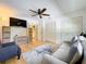 Bright living room features neutral tones, a ceiling fan, and storage shelves, creating a cozy and organized space at 110 N Tremain St # 206, Mount Dora, FL 32757