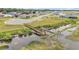 Aerial view of a community pond with a pier and surrounding houses, showcasing the natural beauty of the area at 1146 Enclave Ct., Auburndale, FL 33823