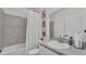 Bathroom with a shower/tub with marble tile, a mirror, and a grey countertop sink at 1146 Enclave Ct., Auburndale, FL 33823