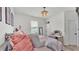 Cozy bedroom with white walls featuring a full sized bed with pink bedding, art, and a dark mirror at 1146 Enclave Ct., Auburndale, FL 33823