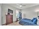 Bedroom with a full sized bed and blue bedding, a dark dresser, and a window with a weight machine at 1146 Enclave Ct., Auburndale, FL 33823