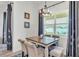 Inviting dining area bathed in natural light, featuring a stylish chandelier and window views at 1146 Enclave Ct., Auburndale, FL 33823