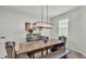 Bright dining room featuring a modern chandelier over a wooden table with stylish tufted chairs at 1146 Enclave Ct., Auburndale, FL 33823