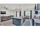 Modern kitchen with stainless appliances, quartz countertop island with seating, and living area at 1146 Enclave Ct., Auburndale, FL 33823