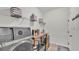 Bright laundry room features a modern washer/dryer, shelving, and pet care station at 1146 Enclave Ct., Auburndale, FL 33823
