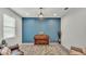 Sitting room showcasing piano, blue accent wall, chandelier, and natural light at 1146 Enclave Ct., Auburndale, FL 33823
