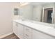 Spacious bathroom featuring double sinks with white cabinets and a large mirror at 1420 Portmore Dr, Mulberry, FL 33860