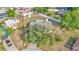 Aerial view of a home with a backyard, storage sheds, partial white fence, and mature trees surrounded by neighborhood at 1423 Ridgegreen N Loop, Lakeland, FL 33809