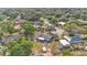 Wide aerial view of a home surrounded by lush trees, showcasing a spacious backyard, patio, and well-kept neighborhood at 1423 Ridgegreen N Loop, Lakeland, FL 33809