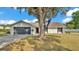 Charming single-story home featuring mature trees, well-maintained lawn, and a welcoming entryway at 1423 Ridgegreen N Loop, Lakeland, FL 33809