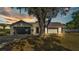 Charming single-story home featuring a well-maintained lawn, mature trees, and an attached two-car garage at 1423 Ridgegreen N Loop, Lakeland, FL 33809