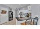 Bright kitchen featuring a breakfast bar, stainless steel appliances, white cabinets, and a modern backsplash at 1423 Ridgegreen N Loop, Lakeland, FL 33809