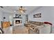 Inviting living room with a stone fireplace, ceiling fan, comfortable sectional, and tasteful decor at 1423 Ridgegreen N Loop, Lakeland, FL 33809