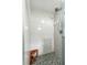 Modern bathroom with walk-in shower featuring stylish gray hexagon tile and a wooden bench at 1648 Skinner St, Lakeland, FL 33801