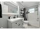 Bright bathroom with a bathtub, shower, storage shelving, and gray vanity with a black faucet at 1648 Skinner St, Lakeland, FL 33801