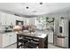 Modern kitchen featuring white cabinetry, granite countertops, stainless steel appliances, and a functional island at 1648 Skinner St, Lakeland, FL 33801