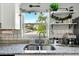Close up of a kitchen window with charming decor and granite countertops at 1648 Skinner St, Lakeland, FL 33801