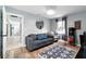 Cozy living room features a comfortable gray couch, round mirror, and light wood-look flooring at 1648 Skinner St, Lakeland, FL 33801