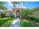 Inviting home entrance with a well-maintained lawn, manicured shrubbery, and a tiled roof at 188 Morning Dew Ct, Winter Haven, FL 33884