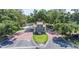 A picturesque entrance to Winterset with manicured lawns, an American flag, and lush trees at 188 Morning Dew Ct, Winter Haven, FL 33884