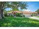 Charming one-story home with a tile roof, manicured lawn, and mature shade tree in a sunny setting at 188 Morning Dew Ct, Winter Haven, FL 33884