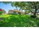 Charming single-story home with lush front lawn, mature tree, manicured landscaping, and a red tile roof at 188 Morning Dew Ct, Winter Haven, FL 33884