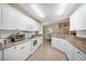 Well-lit kitchen features granite countertops, white cabinets, tile flooring, and modern appliances at 188 Morning Dew Ct, Winter Haven, FL 33884