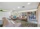 A spacious living room with a bookcase, neutral furniture, and glass doors to the backyard at 188 Morning Dew Ct, Winter Haven, FL 33884