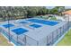 Aerial view of the well-maintained blue and gray tennis and pickle ball courts inside a fenced area at 188 Morning Dew Ct, Winter Haven, FL 33884