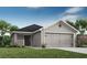 Charming single-Gathering home showcasing a well-maintained lawn and a two-car garage at 1906 Daystar Dr, Haines City, FL 33844