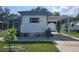View of the side of a single-story home with carport, stone flower beds and well-maintained lawn at 2005 Blue Lake Dr, Lakeland, FL 33801