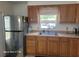 Functional kitchen featuring wooden cabinets, stainless steel appliances, and a sink with a window view at 2005 Blue Lake Dr, Lakeland, FL 33801