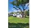 A shed in the backyard of a house with a lush yard and large tree at 2005 Blue Lake Dr, Lakeland, FL 33801