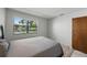 Bedroom featuring a full bed and a window overlooking the front lawn and a wood-paneled door at 2025 Sylvester Rd # P4, Lakeland, FL 33803