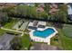 Aerial view of a community pool and shuffleboard courts, surrounded by green lawns and mature trees at 2025 Sylvester Rd # P4, Lakeland, FL 33803
