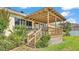 View of the covered back porch featuring wood railings and stairs leading to the backyard at 2025 Viewpoint Landings Rd, Lakeland, FL 33810